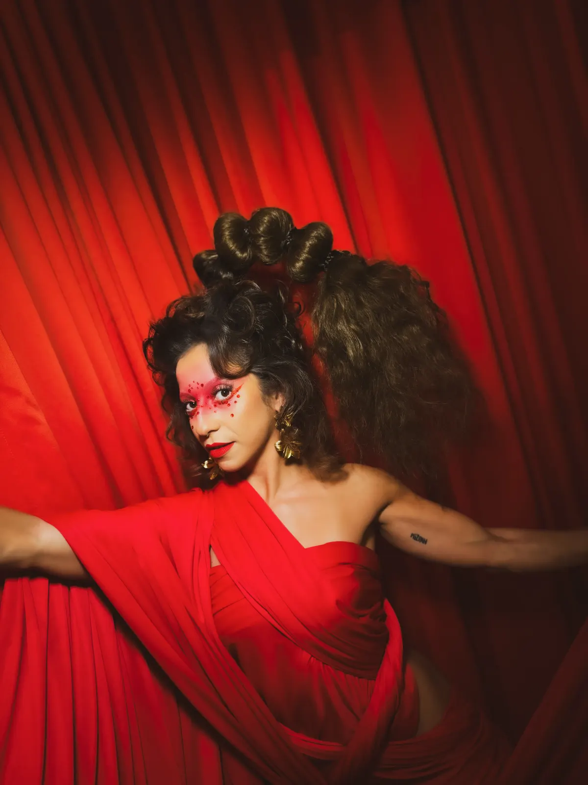 Editorial portrait of Sara Brigite against a red curtain